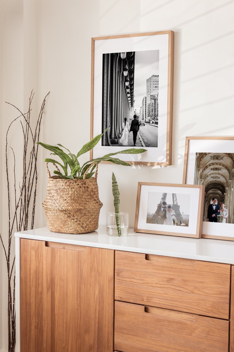 a wall with three framed newborn pictures