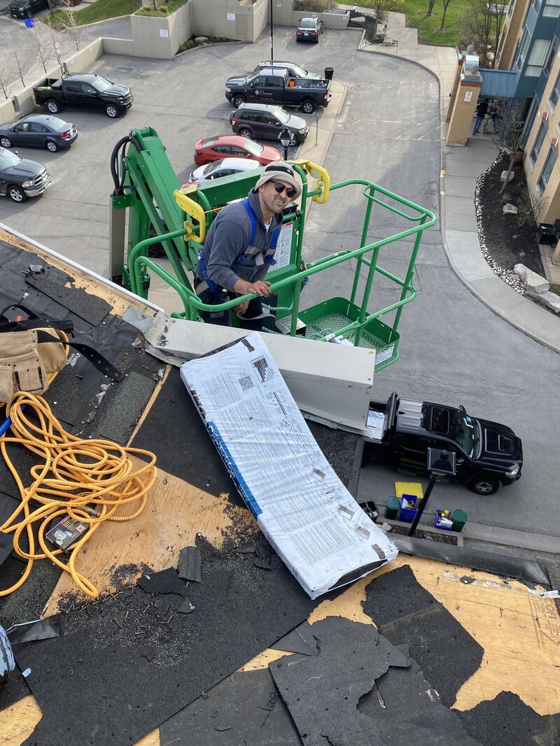Roofer replacing shingles on roof