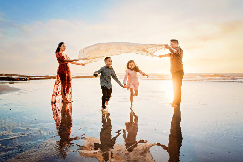 Oceanside family photographer, Tristan Quigley, captures a fun family playing on the beach at sunset