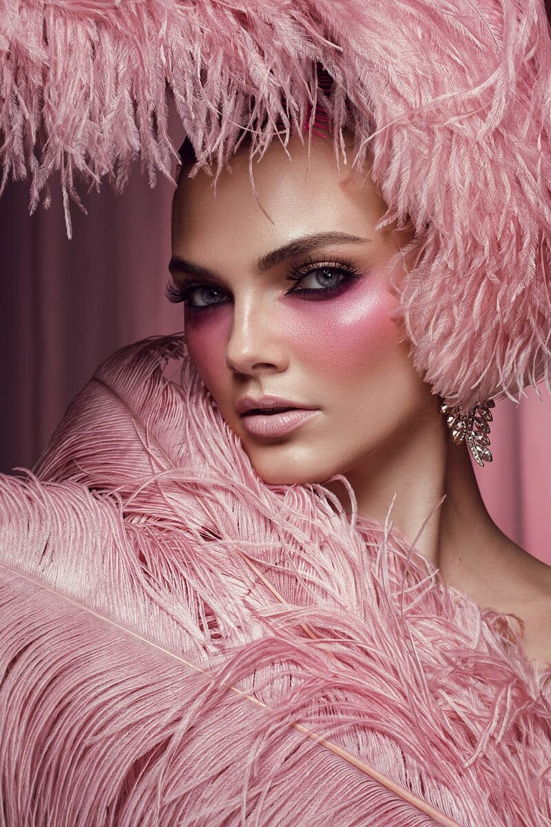 Close-up portrait of Ashley in a pink ruffled outfit with dramatic eye makeup, captured by Ylva Erevall.