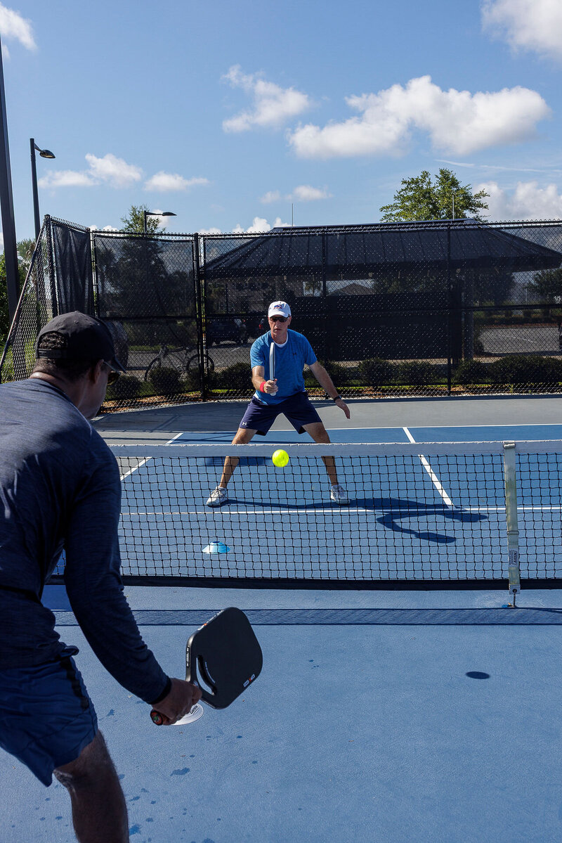 Mark practicing pickleball with a client