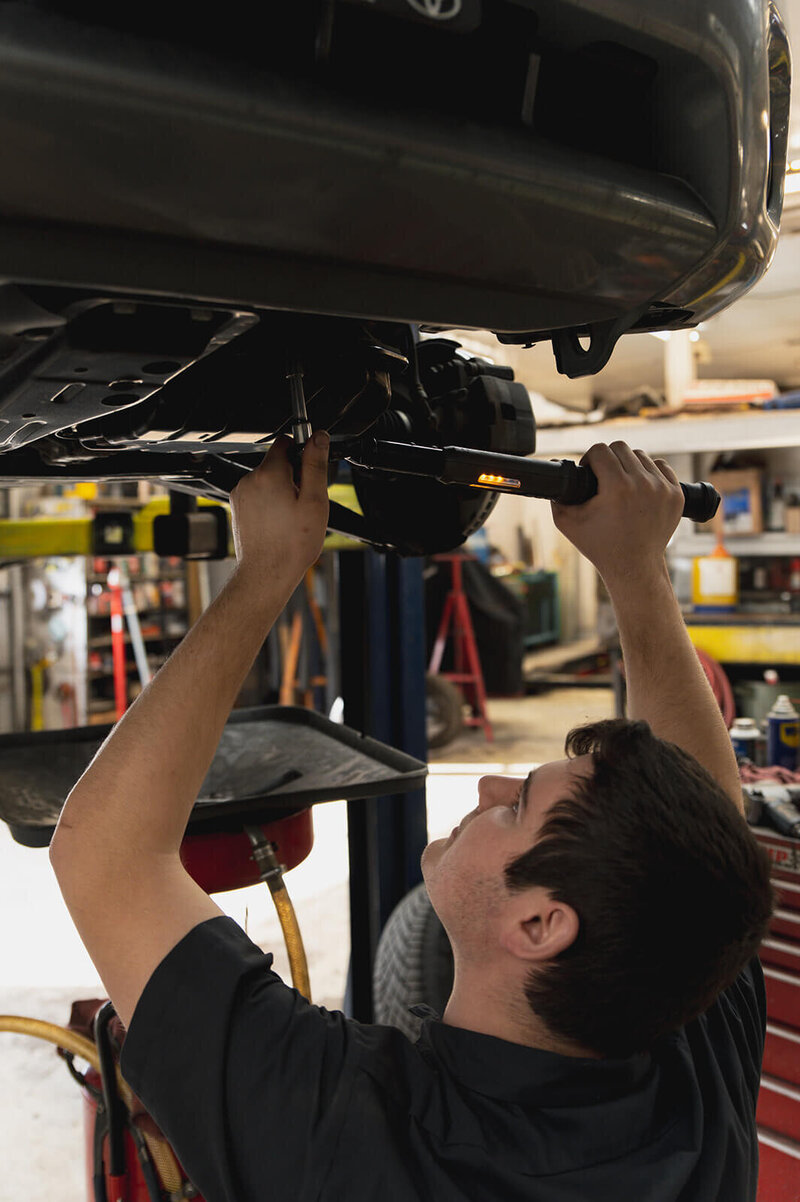 Mechanics in automotive shop inspecting vehicle