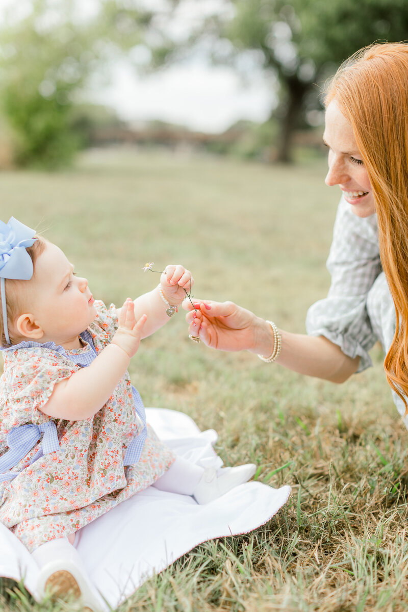 Mother hands baby a flower