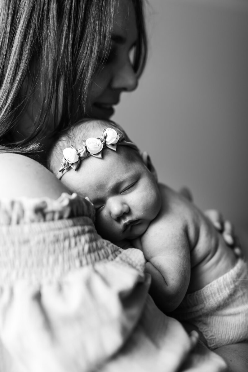 Newborn baby being held by their mother black and white image
