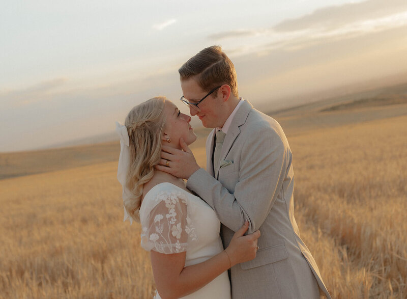 A groom gently holds the side of his bride's neck as Brittney Ann Photography takes bridals for their wedding.