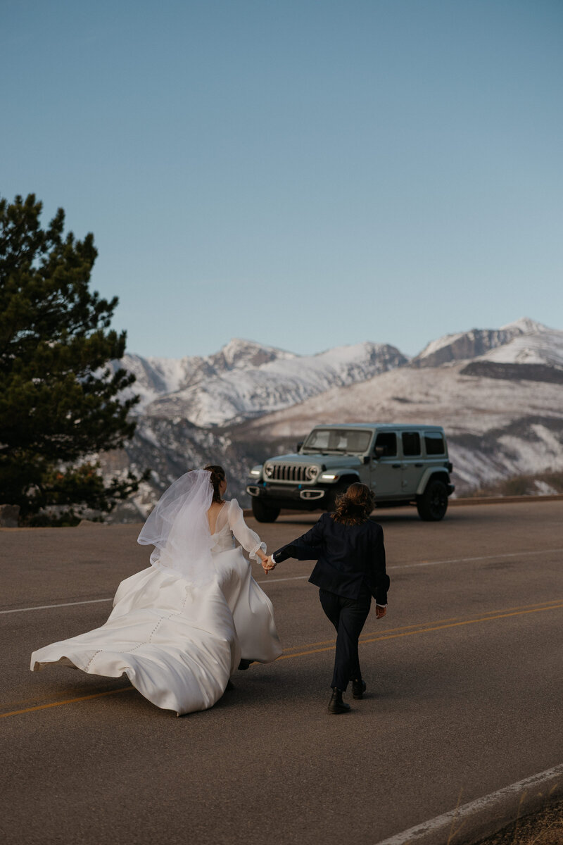 Couple sneaking a kiss in a black dress and black veil on their wedding day