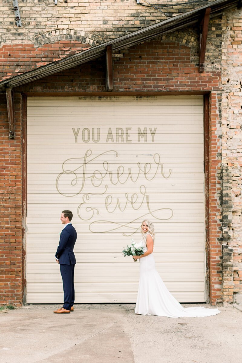 Bride standing behind groom for first look, taken by wedding photographers in minneapolis