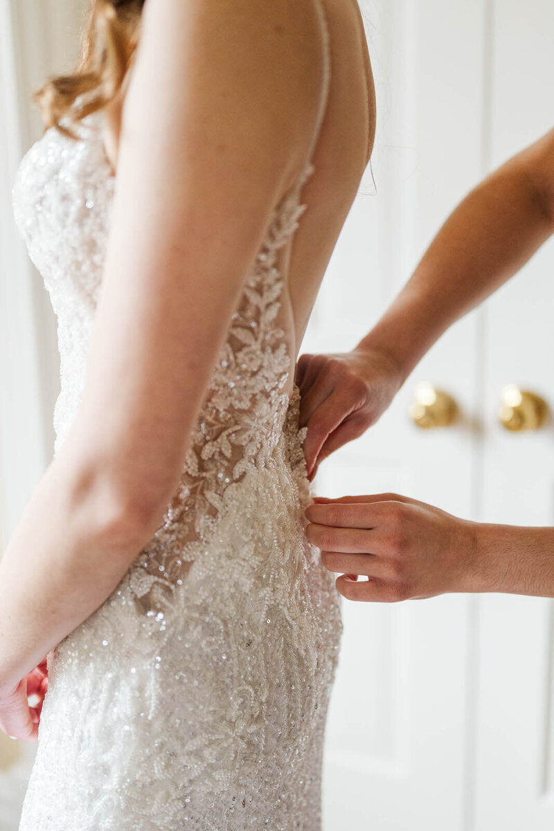 Mom buttons bride's dress on wedding day at Jim Beam Distillery