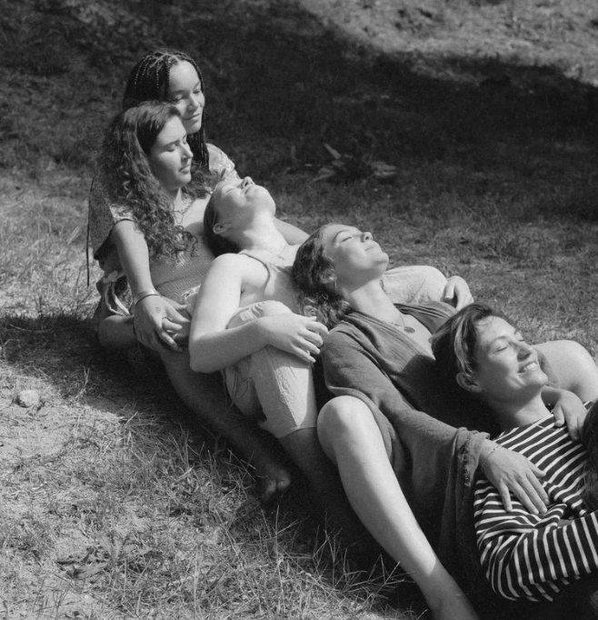 Women covered in mud holding each other