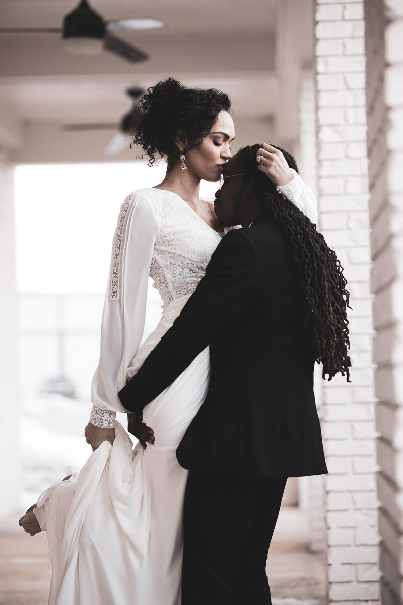 Black Bride From Indianapolis kisses the grooms forehead and he lifts her  up in her white wedding gown!