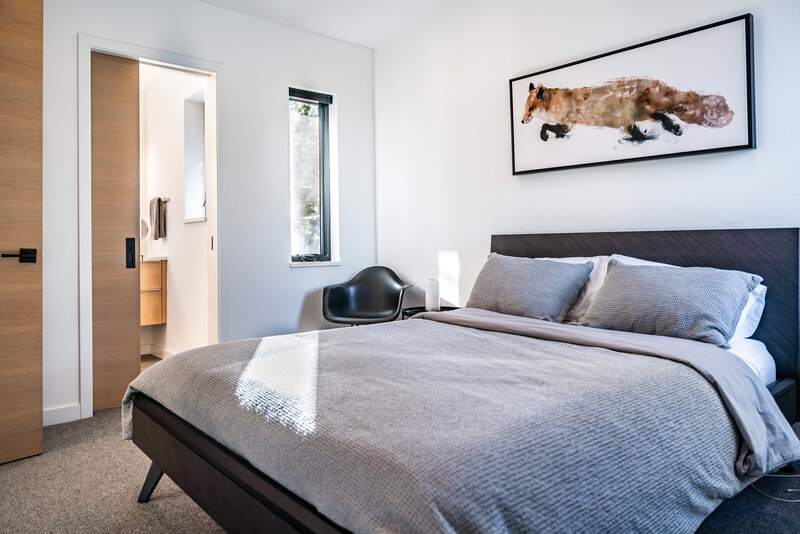 modern-mountain-home-bedroom-white-oak-pocket-door-sunlight