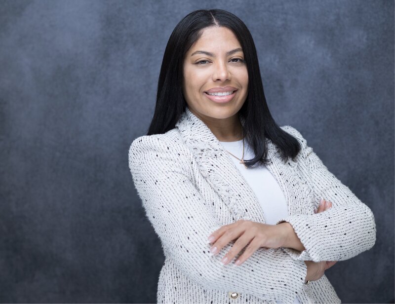 maya Hylton headshot with her hands crossed over her chest, smiling at the camera