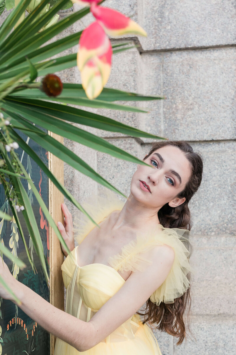 brunette girl posing for photo by palm tree 