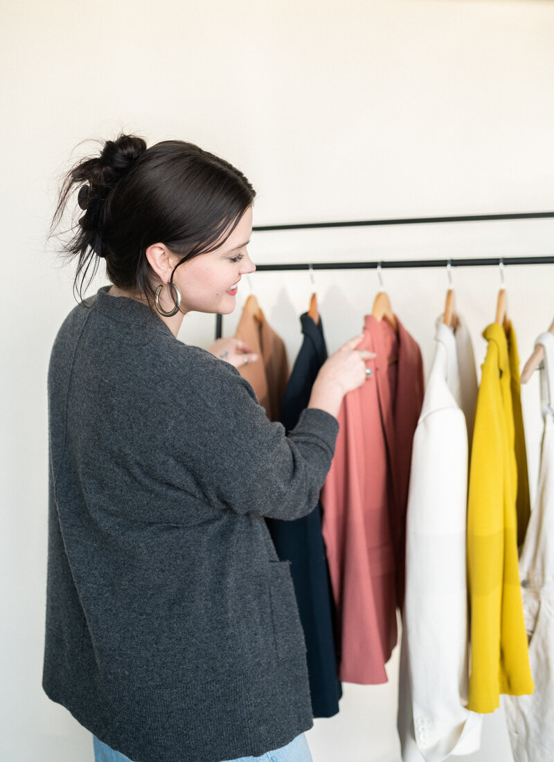 stylist and creative directior Makenzie picking out clothes for a brand photoshoot.