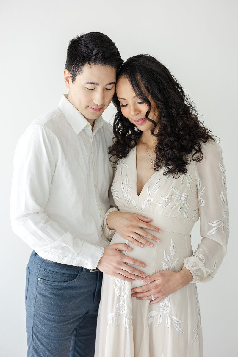 husband and pregnant wife touching  her baby bump