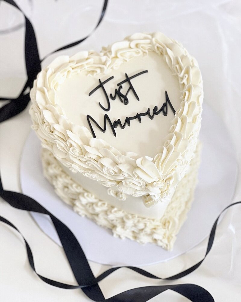 White vintage style lambeth style heart cake with Just Married & black ribbons