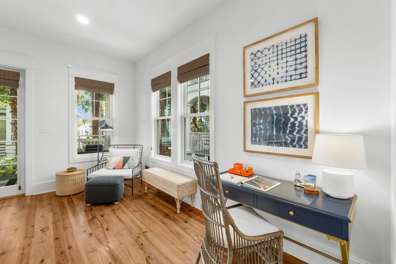 Work-from-vacation friendly desk nook with lounge chair and large windows in this beach rental near Santa Rosa Beach.
