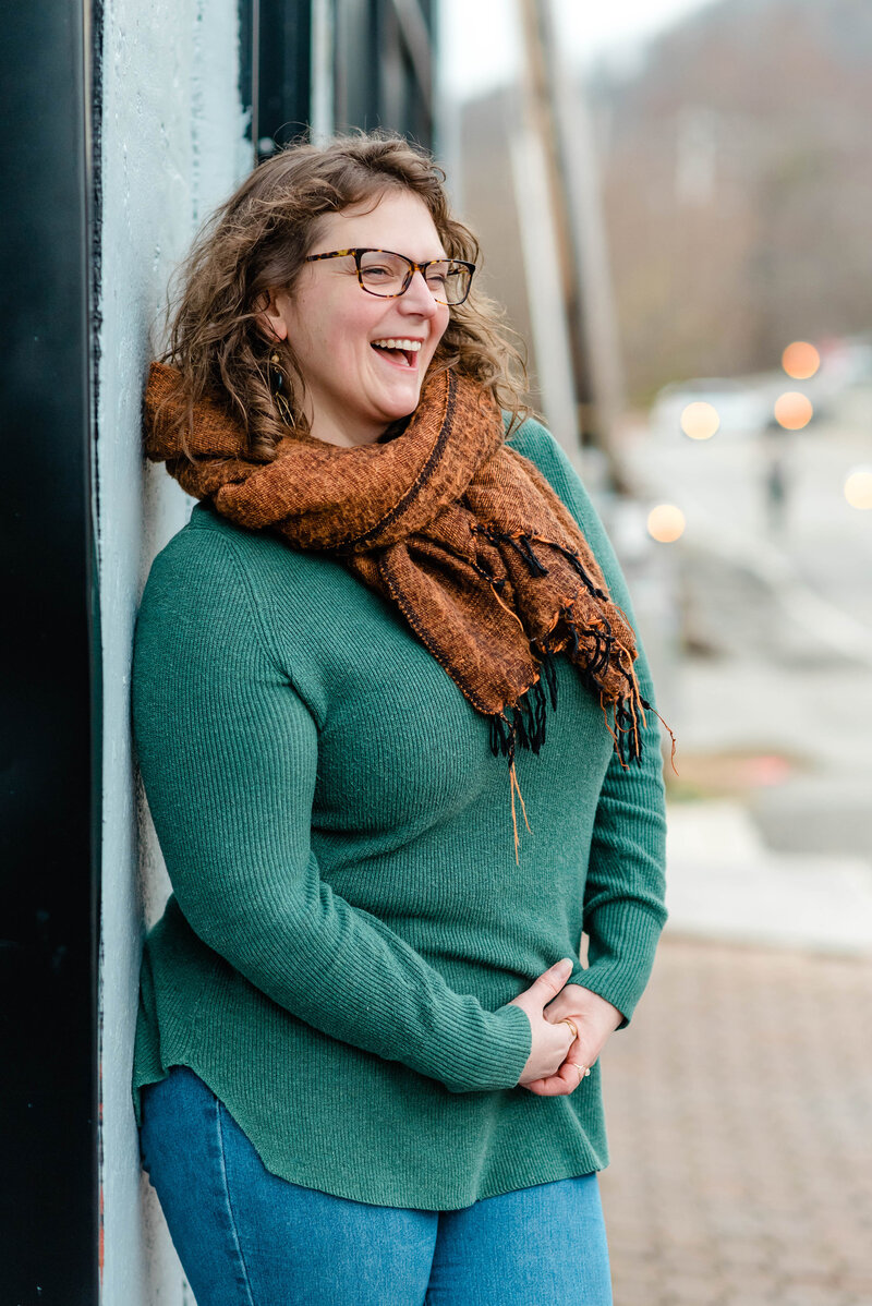 Boone, NC based family, wedding and boudoir photographer Ashley Kubota smiles at the camera.