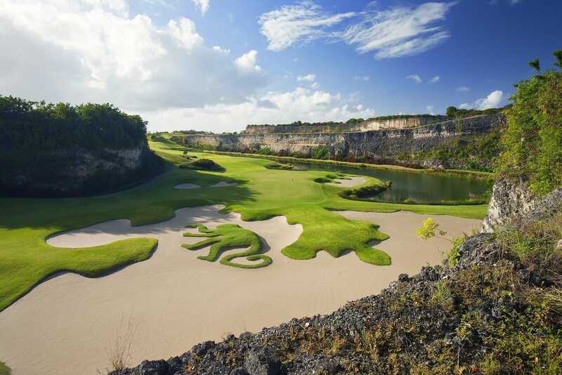 The iconic Green Monkey Golf Course in Barbados, featuring a signature sand trap design shaped like a green monkey, set against a stunning limestone quarry backdrop.
