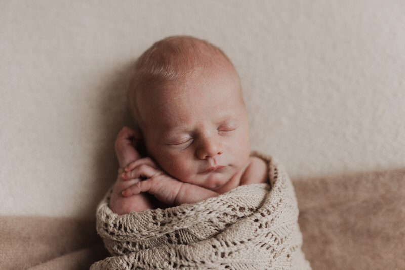 up close photo of newborn baby in mom's arms