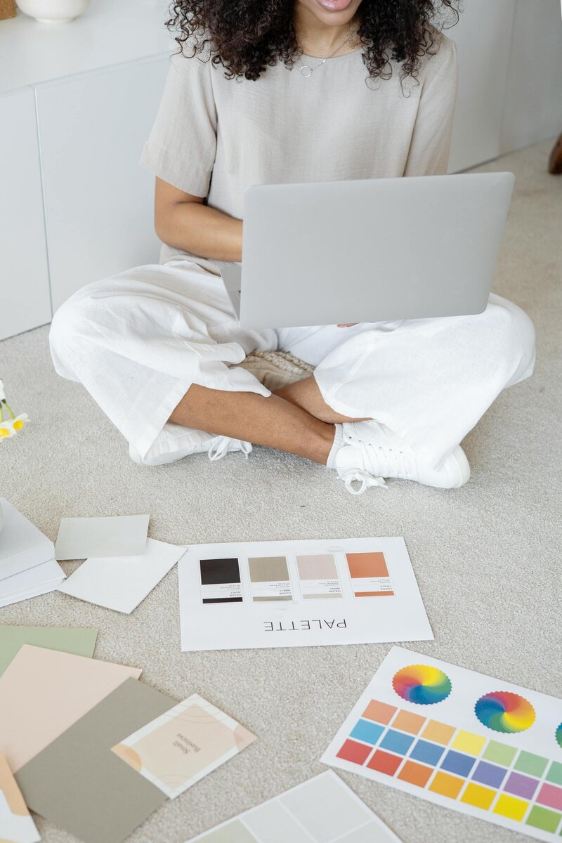 woman on a laptop creating with color palettes and inspiration in front of her