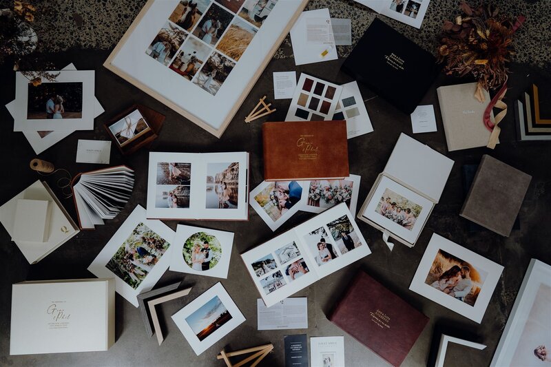 A flatlay of albums, prints and wedding photographs in frames printed with Queensberry Professional Print Lab in New Zealand