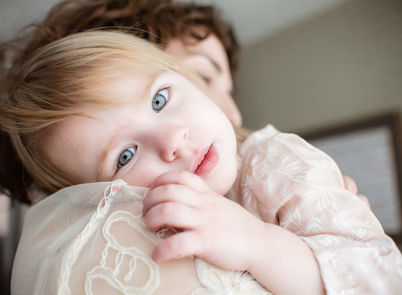 Portrait of Mother holding young girl with big blue eyes. Motherhood & newborn Photographer - Philadelphia and Bucks County Photographer