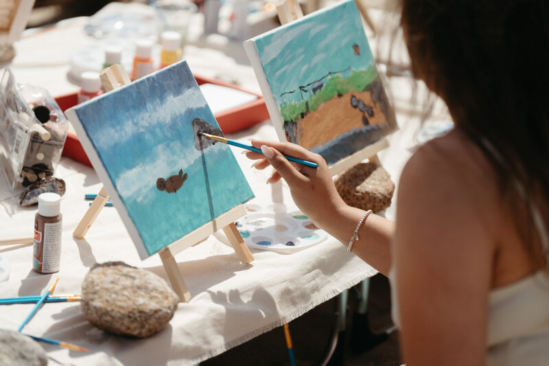 Bride paints a canvas during her elopement for an Artistic Elopement Idea