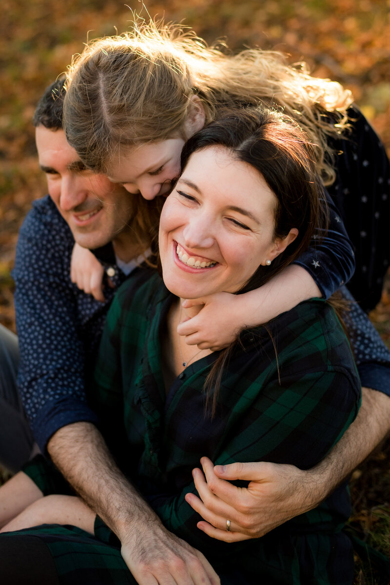 father and daughter hugging mother