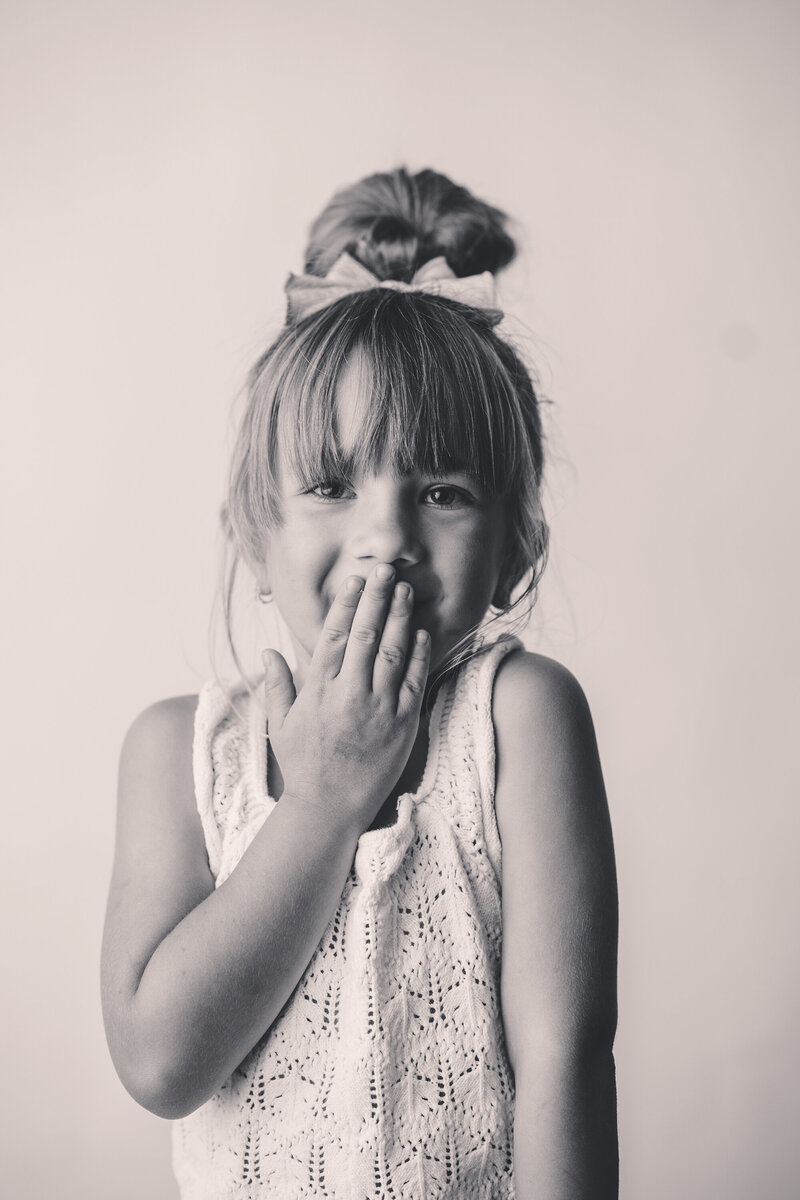 Young girl looks cheekily at the camera during Personality Portrait Session in Charleston, SC. 