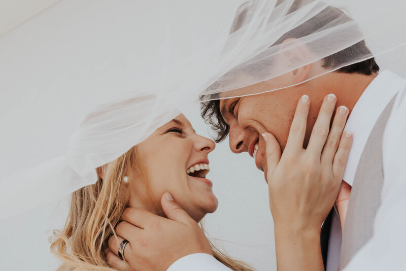 newlyweds smile under veil