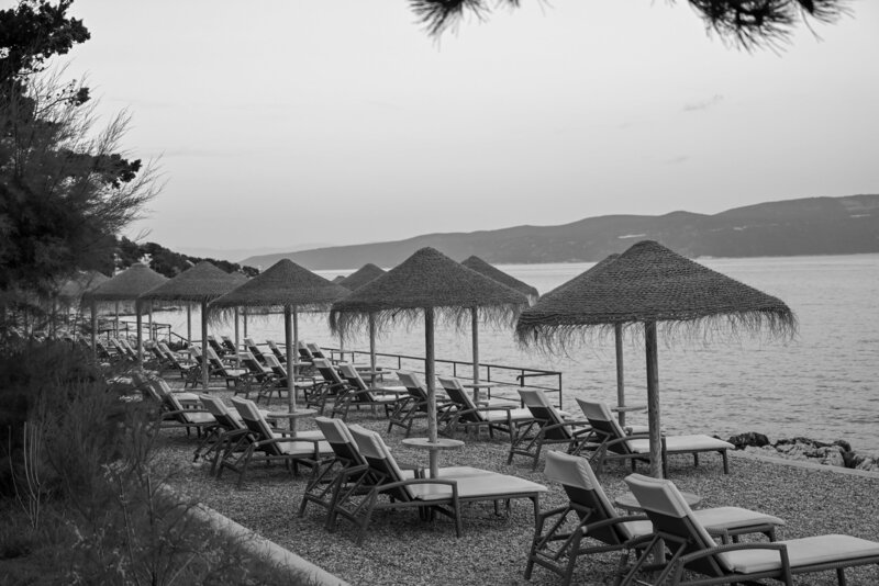 white sun loungers and umbrellas by the ocean