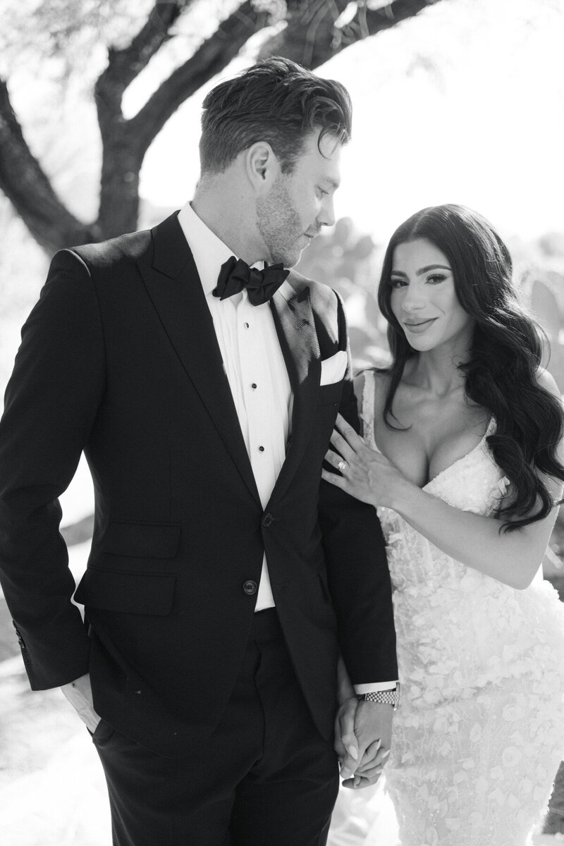 Clean Black and white portrait of groom looking at bride and bride looks at the camera. 