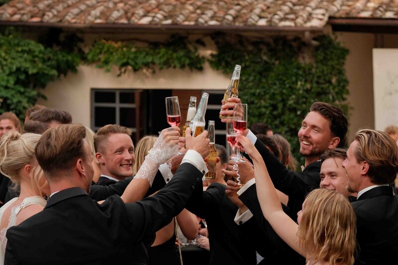 vriendengroep die proost in het sfeervolle italie tijdens trouwerij