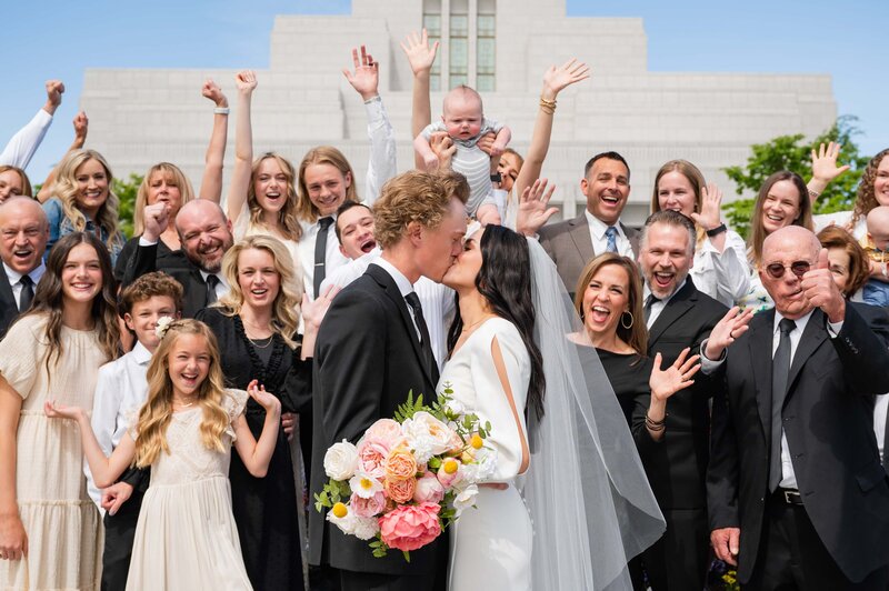 Bride and groom surrounded by cheering family and friends at the Draper Temple in Utah.