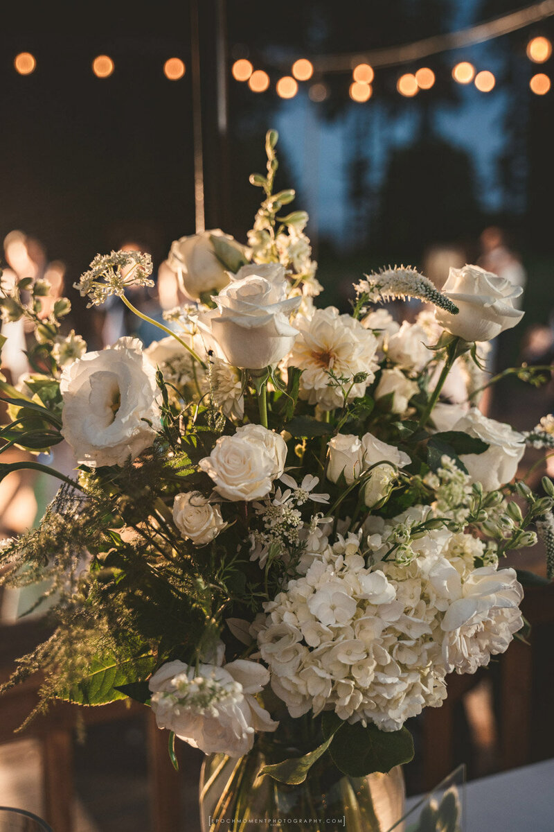Elegant white rose wedding centerpiece at reception