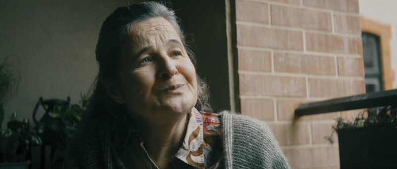 A nighttime scene with neon reflections, highlighting the emotional tone of the film.