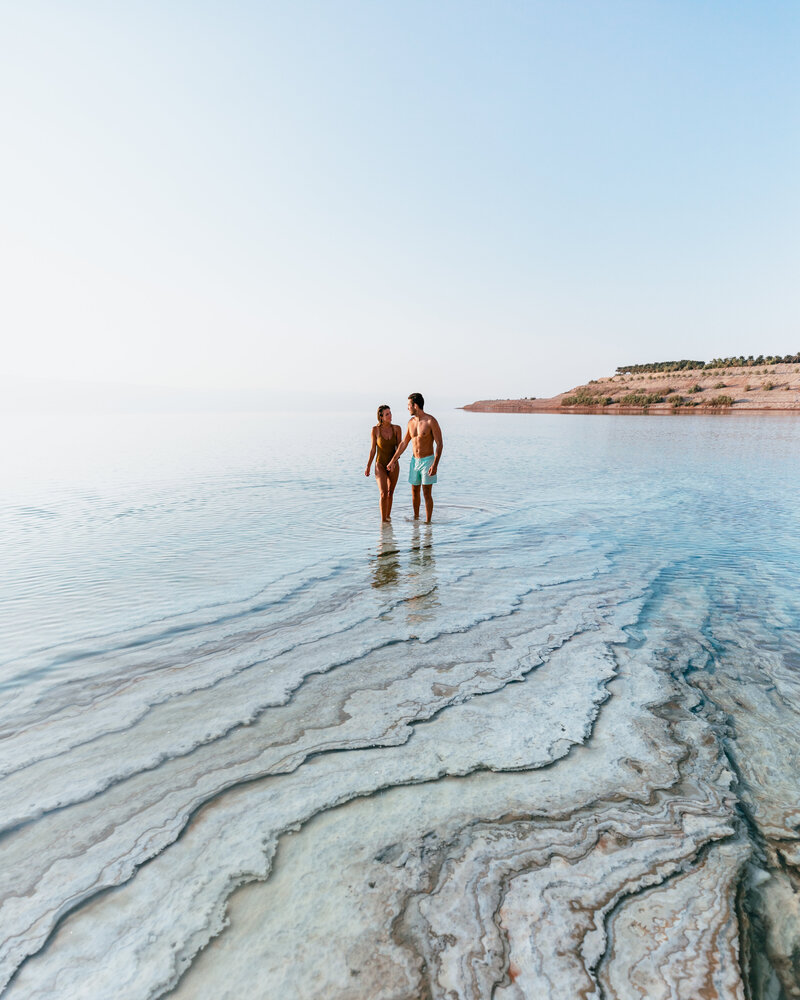 man and woman walking in ocean