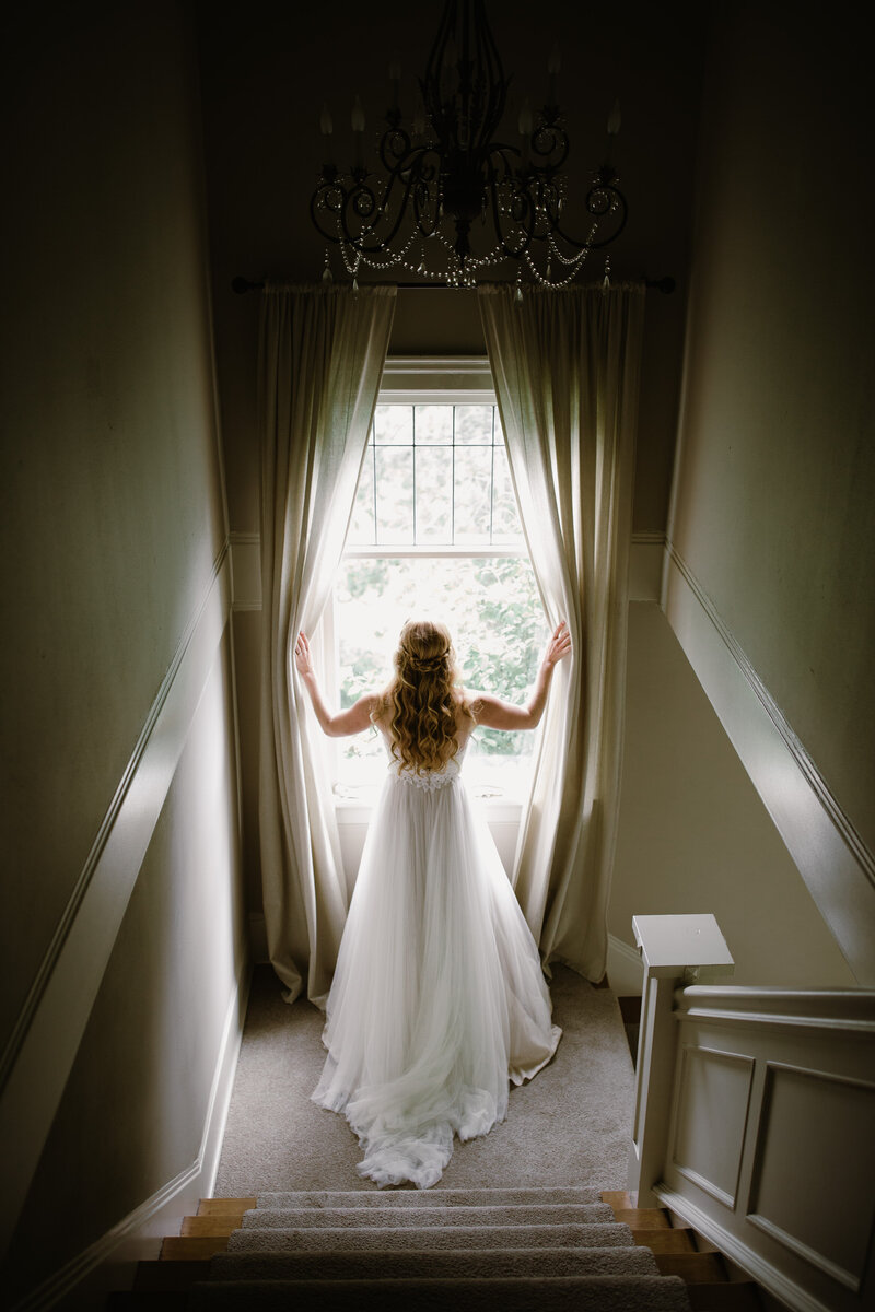 Bride looking out of a wedding in a stairwell.