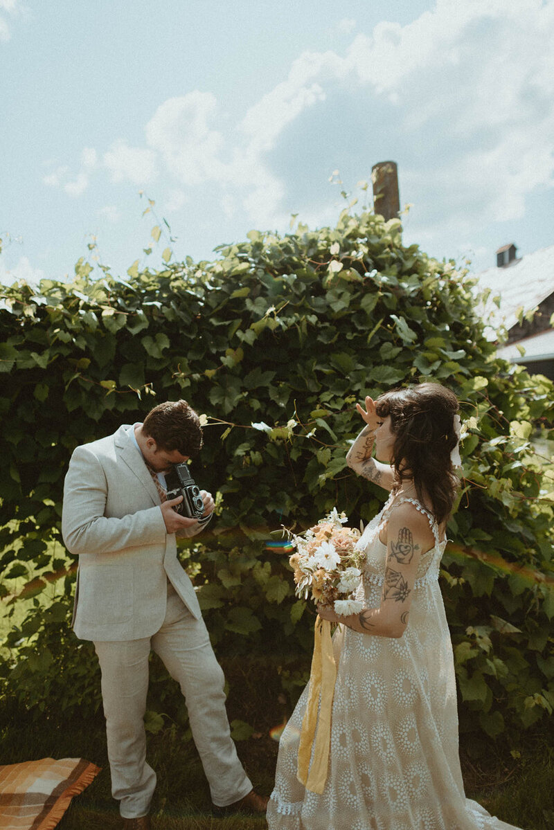 man taking film photos of bride