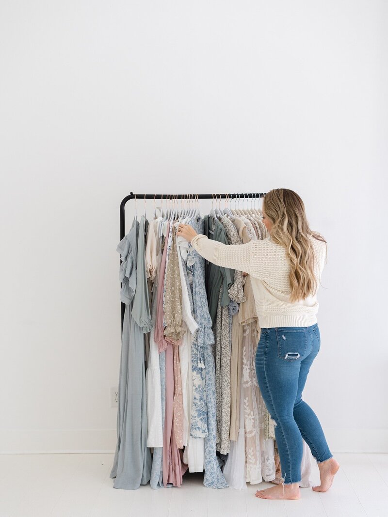 full-body-image-of-woman-sifting-through-dresses