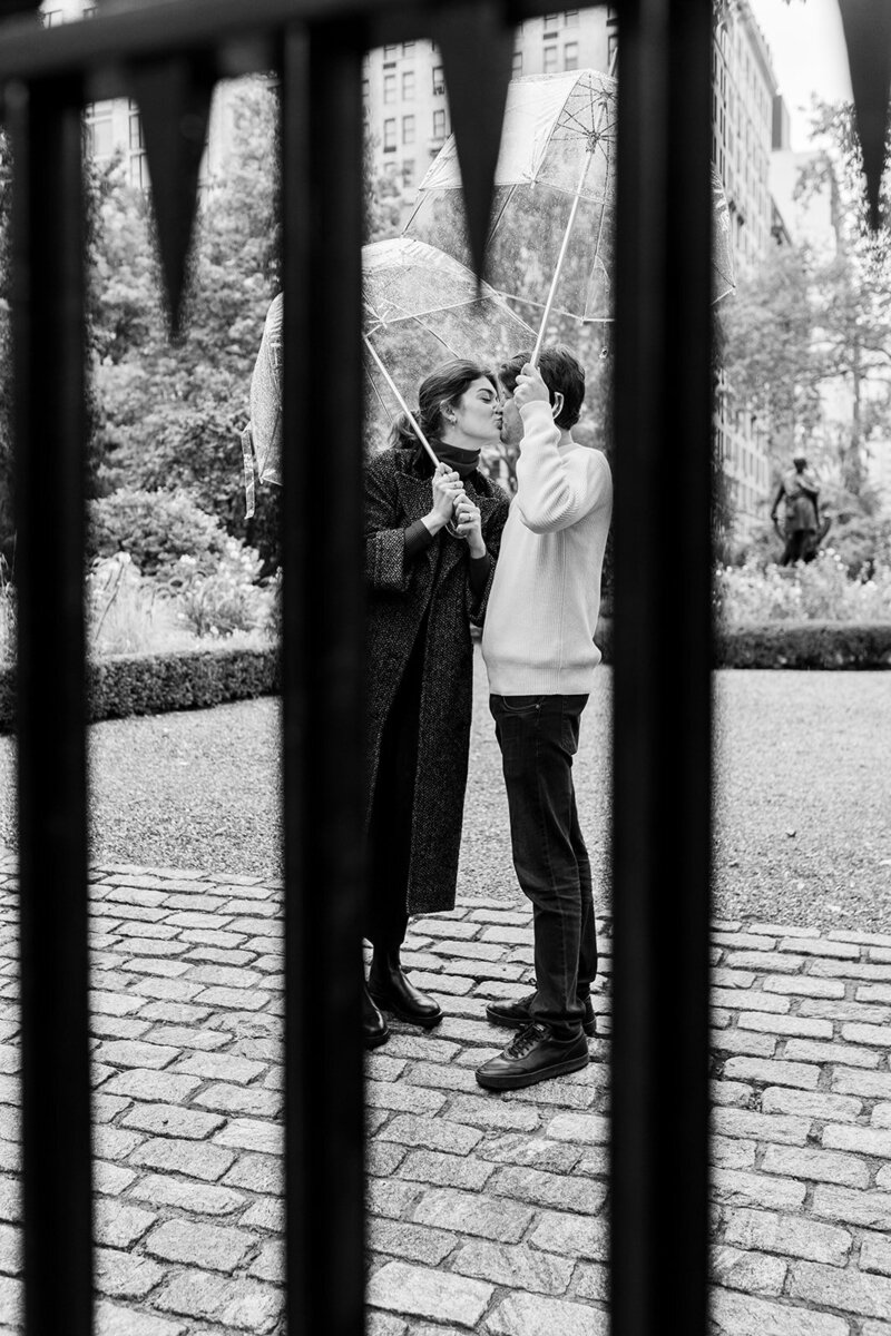 couple with umbrellas at Gramercy Park in NYC