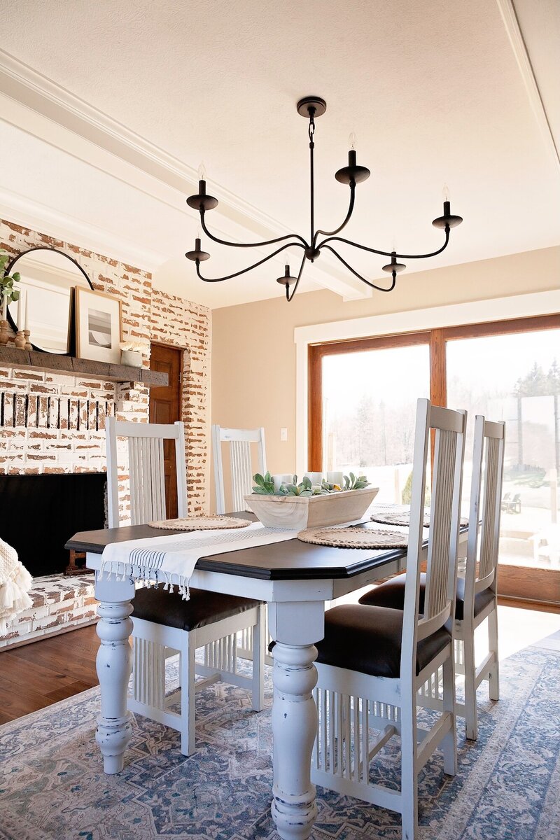 Farmhouse dinning room featuring a worn white washed textured fireplace.