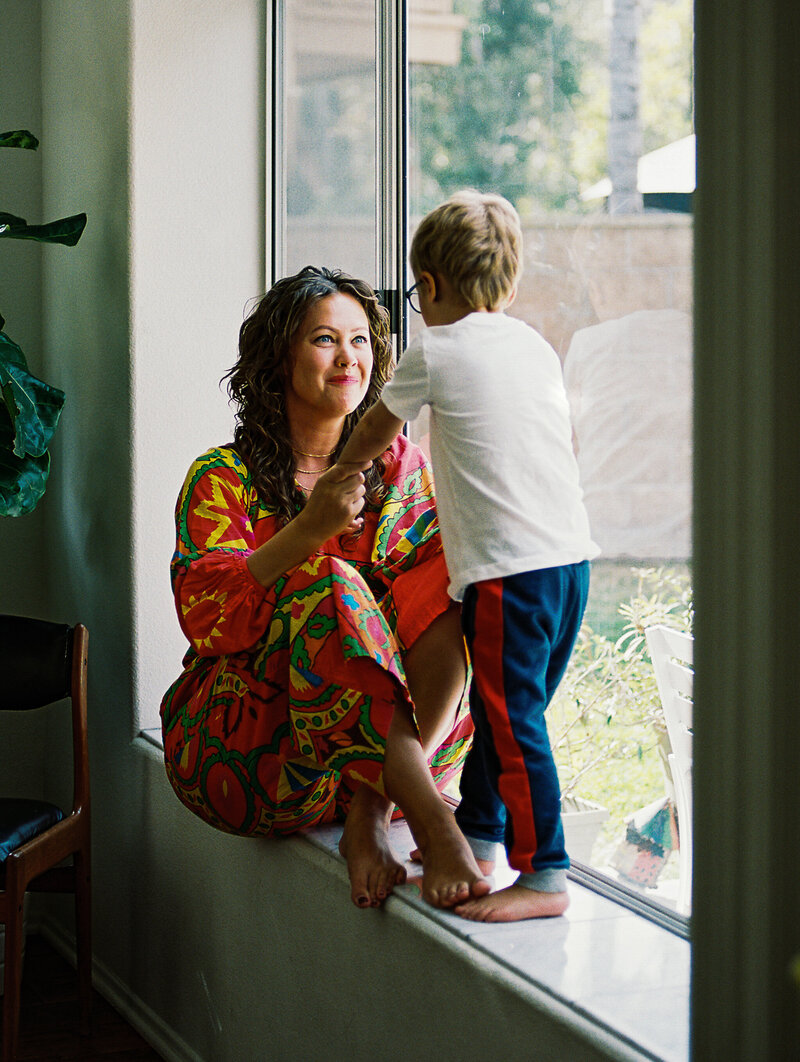 mom and son sit in a window sill during broomfield photography session