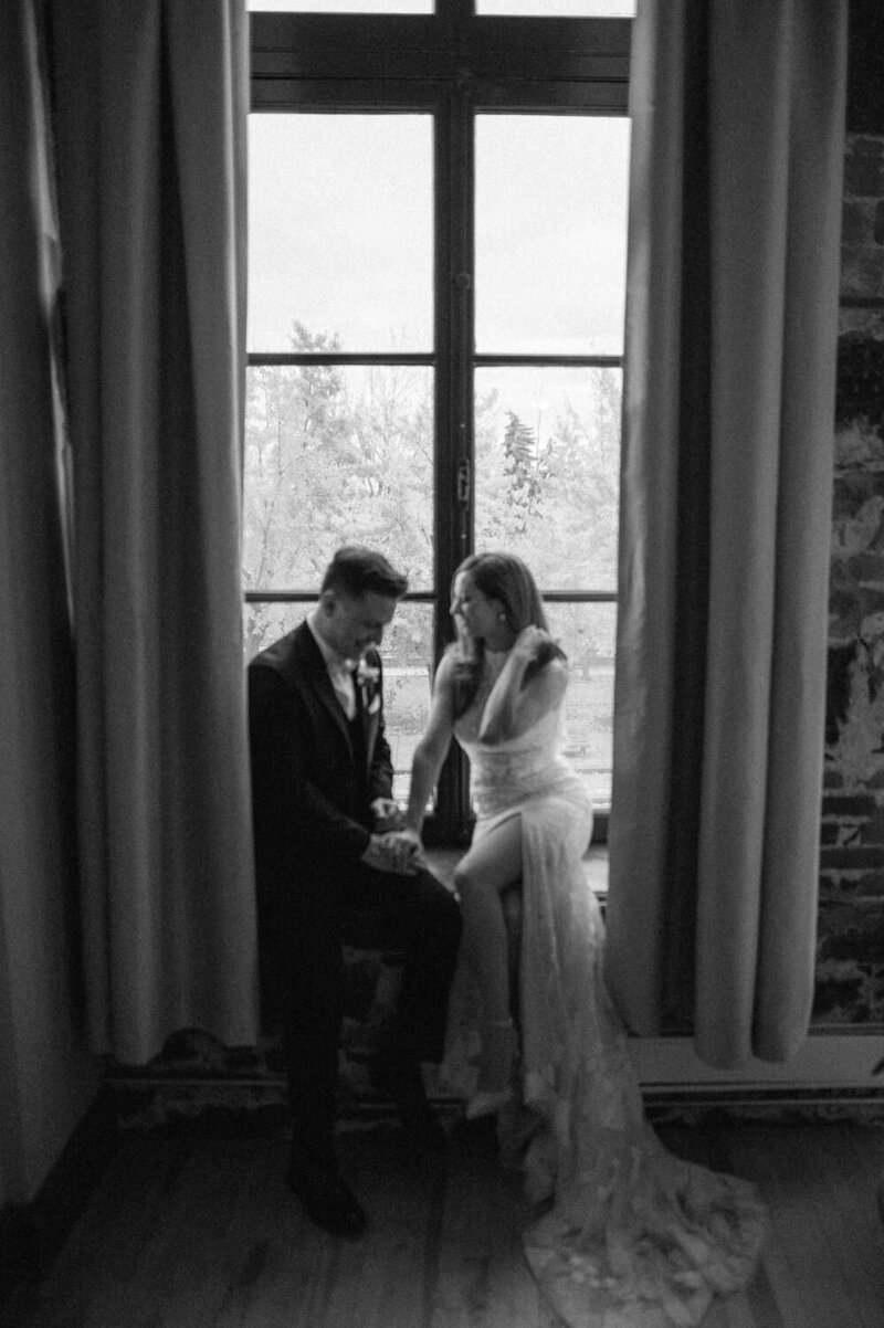The bride and groom share an intimate, light-filled moment by the window in their room at Auberge du Vieux-Port in Montreal — a scene full of softness and elegance in the heart of Old Montreal