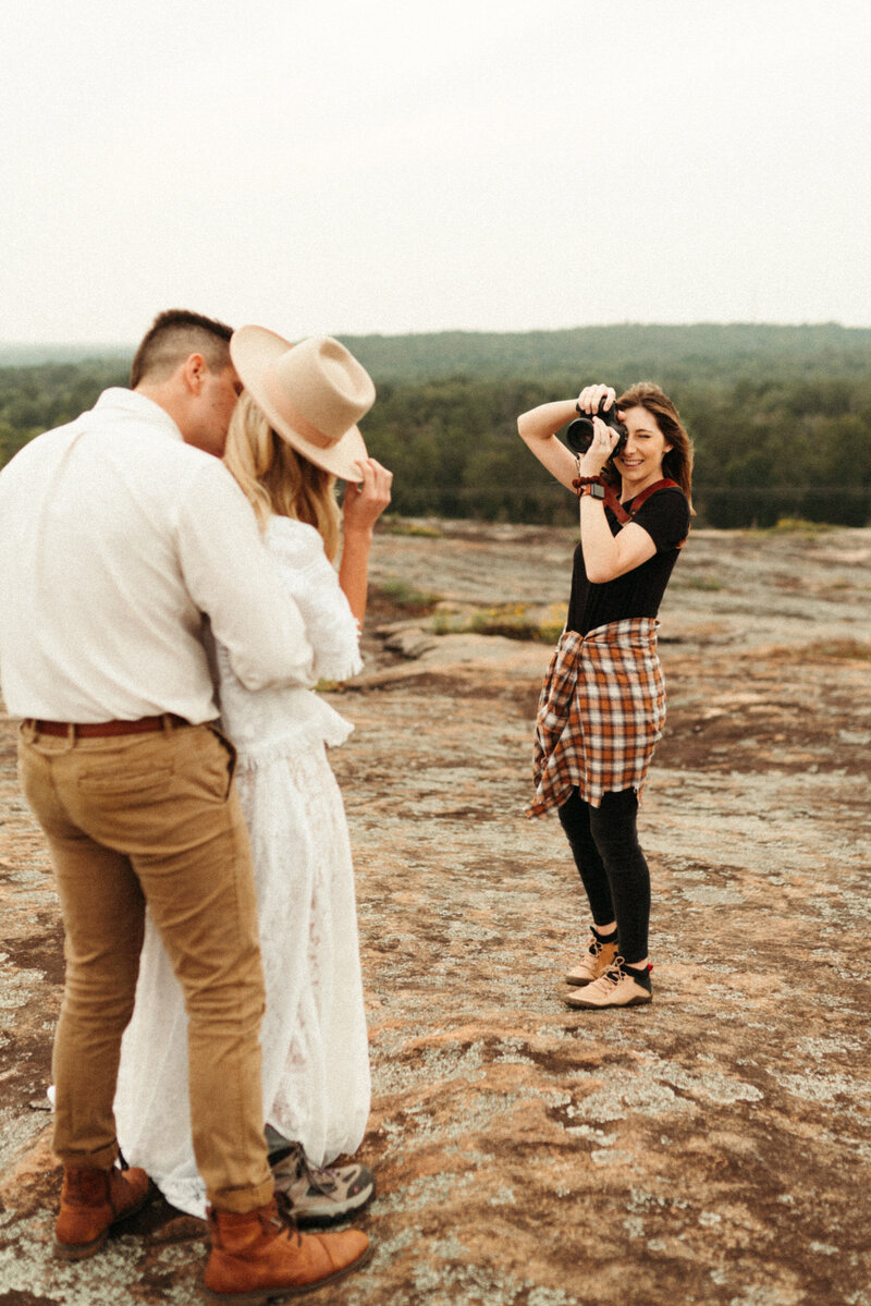 Elopement photographer photographing boho bride and groom on mountaintop