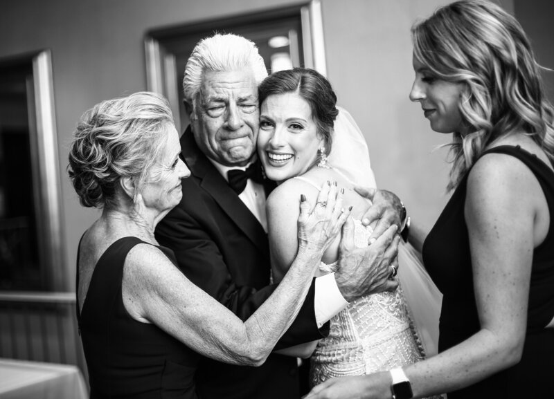 Bride hugs father with her mother and sister at Sheraton Erie Bayfront Hotel