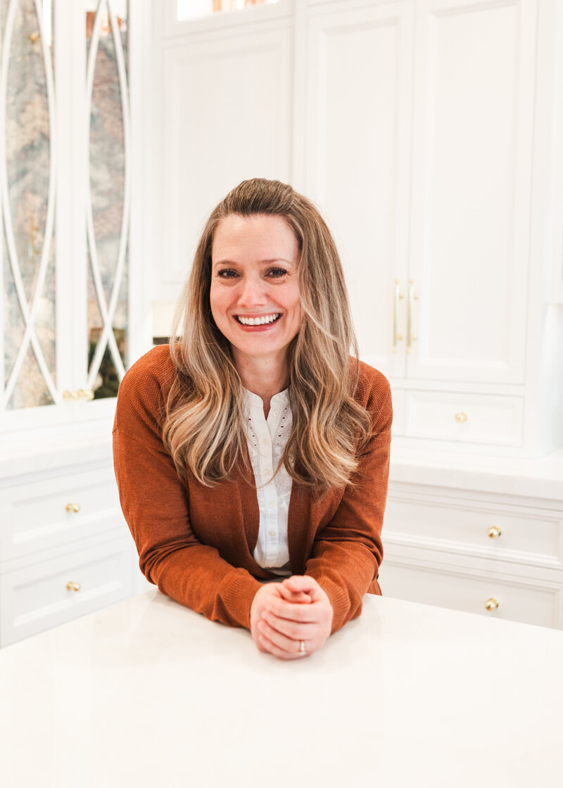 woman leaning over counter wearing orange blazer