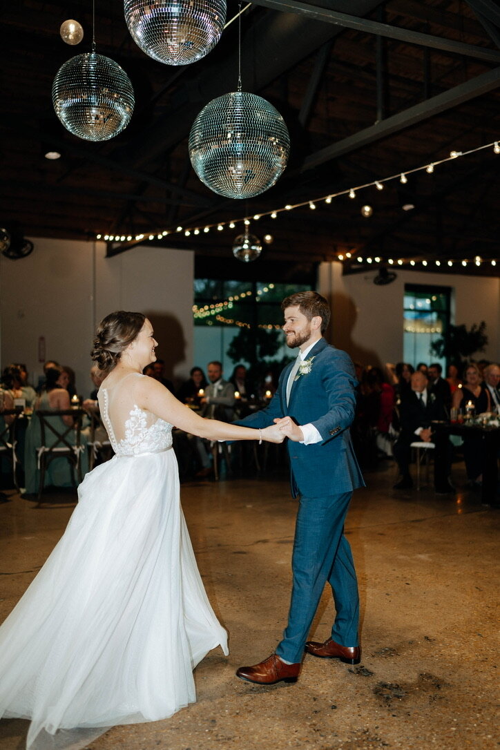 Married couple first dance in front of their guests