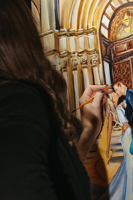 A close up of Debbie painting on canvas